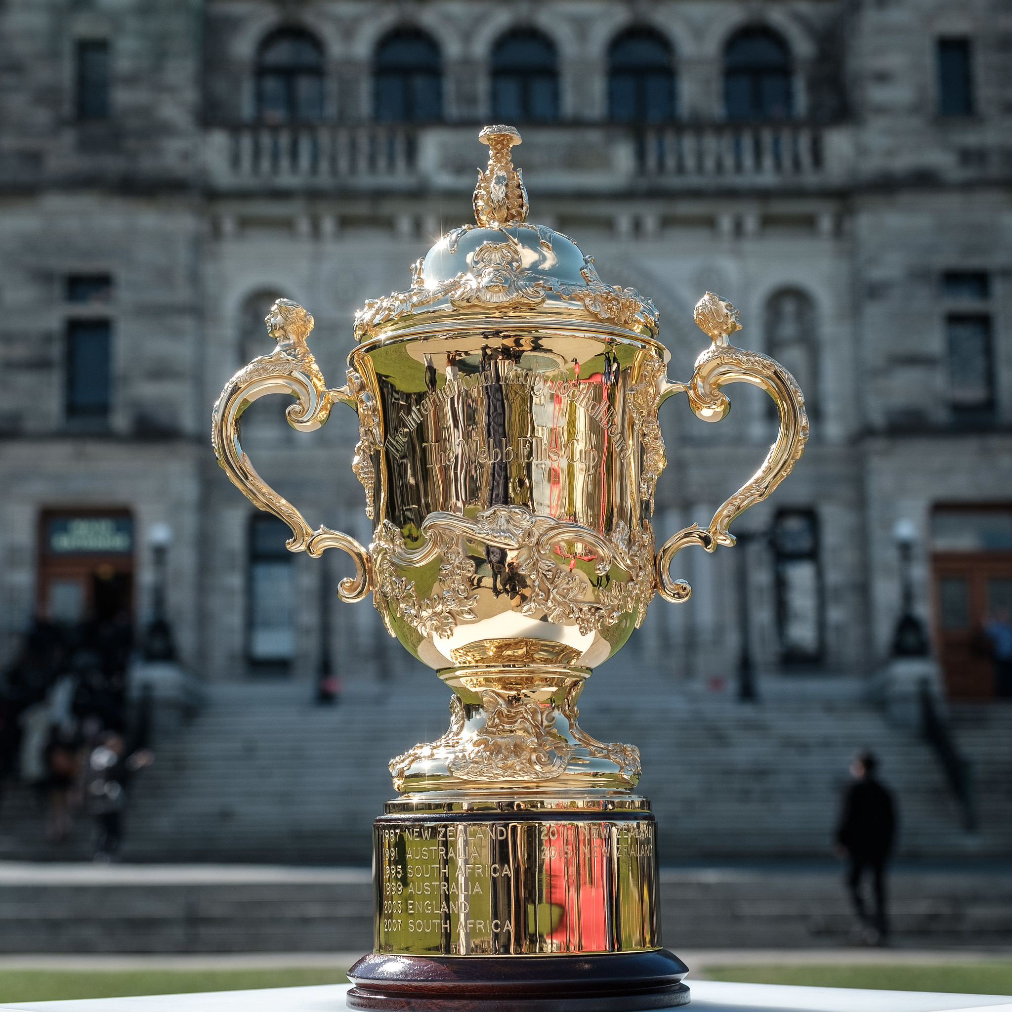 The Webb Ellis Cup in front of a grey building