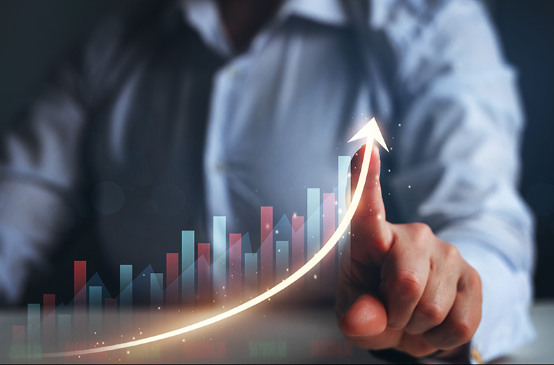 A businessman pointing at a graph with an upward arrow stock photo.
